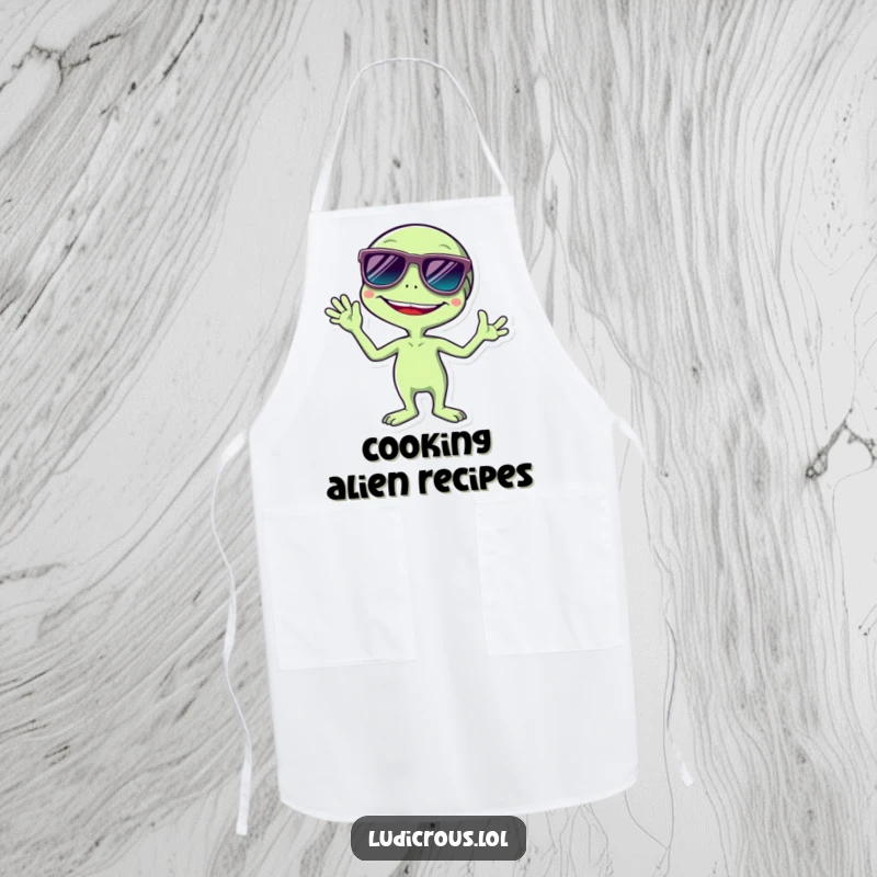Funny apron illustration of a giggling alien wearing oversized sunglasses and giving a cheerful wave, ready for kitchen adventures.