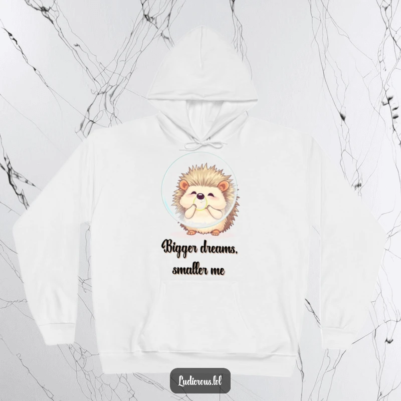 Funny hedgehog hoodie showing a fluffy animal comically trying to blow a bubble that dwarfs its entire body, exuding effort and playful humor.