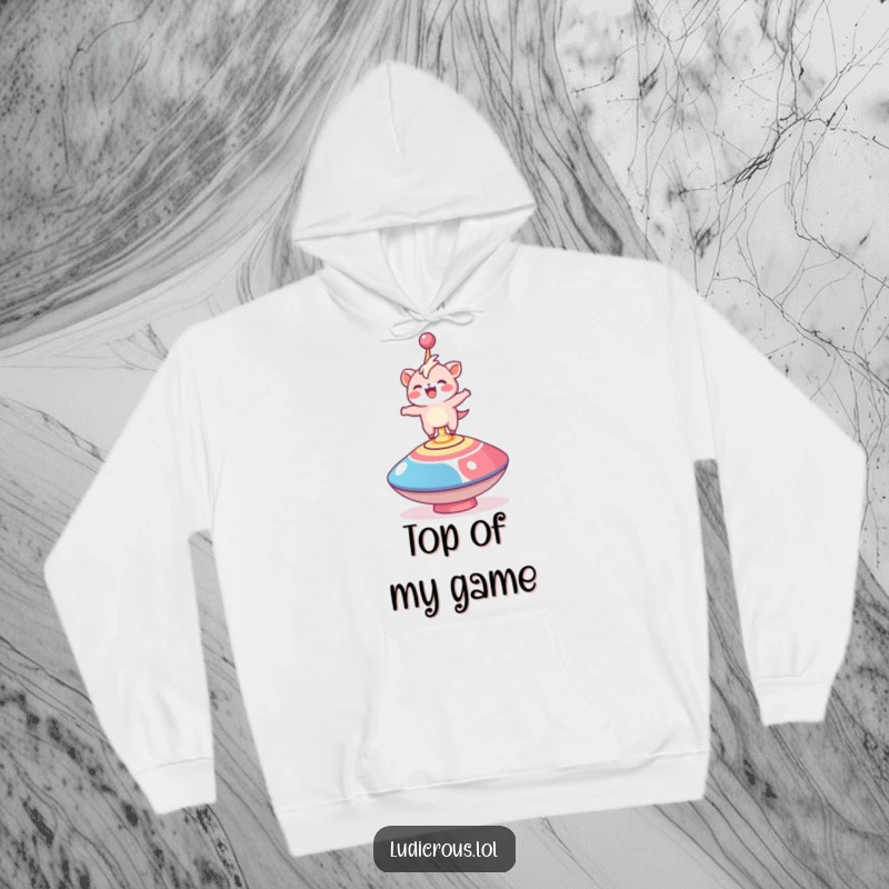 Funny hoodie showing a delighted creature precariously balancing on a huge, fast-spinning top, designed for cozy amusement.