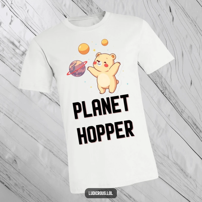 Funny bear gleefully juggling multiple planets with visible delight and wonder, printed on a hilarious t-shirt.