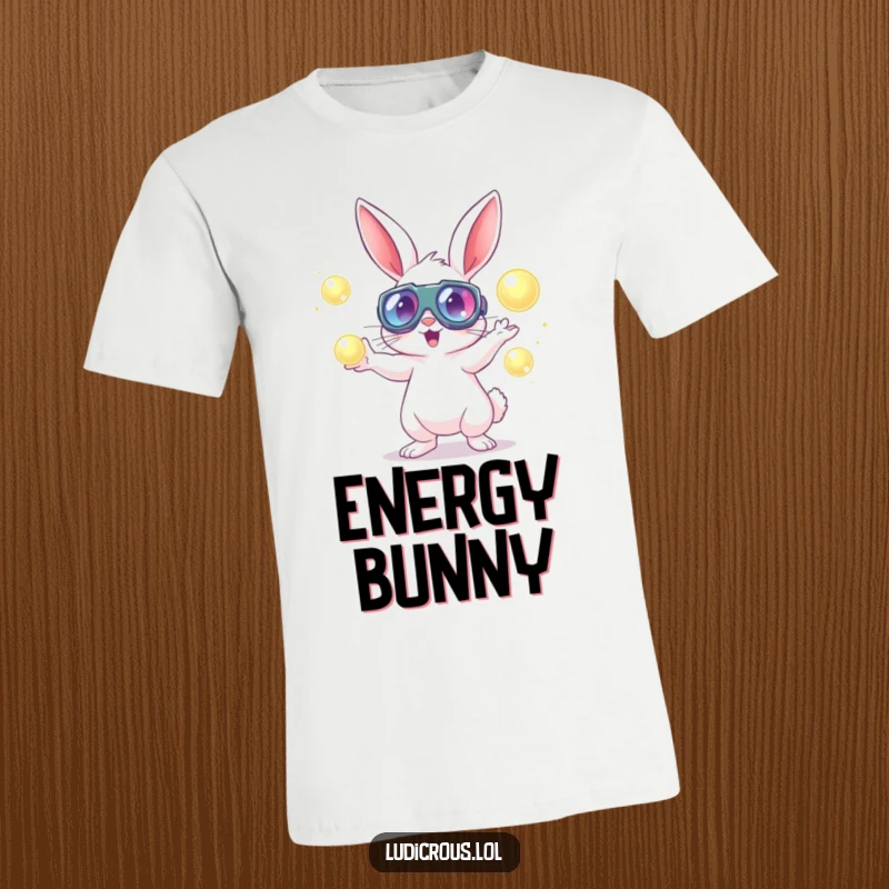 A rabbit wearing large goggles energetically juggles glowing orbs on a fun and humorous t-shirt.